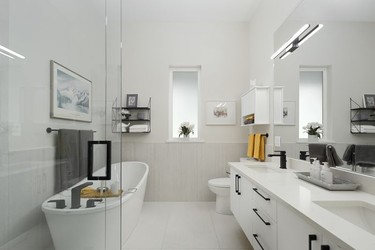 The ensuite has enough space for a freestanding tub and shower. Largescale ceramic tiles create a visually open feel.