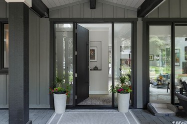 The home's entry opens to a wall displaying a painting of the owners' first home.