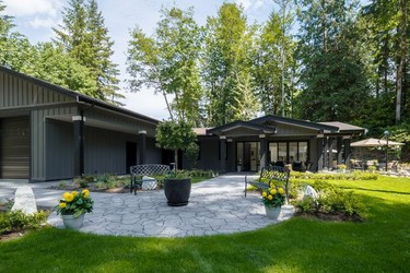 Landscaping by Van de Poll Garden Design accommodates outdoor-entertaining spaces for both families, a shared fire pit and a large yard with play space for the kids.