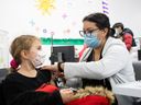 A girl receives her shot at a vaccination clinic in Montreal, Nov.  26, 2021.