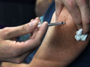 A nurse injects a COVID-19 vaccine.