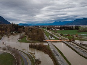 A Tiger Dam is placed on all lanes of the closed Trans-Canada Highway near the flooded Sumas River on December 1, 2021.