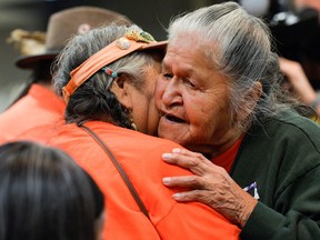 Residential school survivor Evelyn Camille is embraced at a presentation of the findings on 215 unmarked graves discovered at Kamloops Indian Residential School in Kamloops.