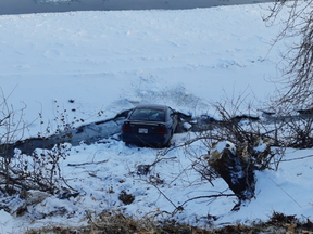 On Dec. 26, 2021, Tracy Smith's 1995 Mustang hit ice on Schubert Drive, careening between two trees and over the embankment sideways, avoiding a rollover and ending up nose-first in the river, its rear wheels on an iced-over portion of the waterway.