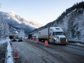 Transport trucks travel on Coquihalla Highway after it was reopened to commercial traffic northeast of Hope on Monday, Dec. 20, 2021.