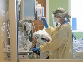 A nurse prepares to treat a patient in the ICU at Surrey Memorial Hospital in June.