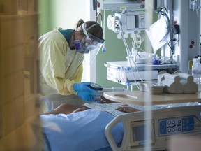 A nurse treats a patient in the ICU at Surrey Memorial Hospital in June 2021.