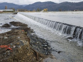 Aftermath of heavy flooding on the Sumas prairie in Abbotsford on Dec. 2, 2021. Water pours over Boundary Road from the U.S. side, undercutting the roadway.