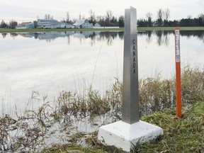 Water is slowly receding from flood devastated Sumas prairie in Abbotsford on Friday, Dec. 3, 2021. The international boundary markers on Boundary Road in Abbotsford are shown here as the road lies on the Canadian side of the U.S.-Canada border.