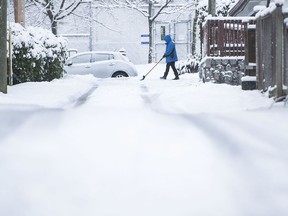 La neige a accueilli les gens dans le matin de Noël du Lower Mainland le samedi 25 décembre 2021, créant un Noël blanc.  Sur la photo, une personne déblaye la neige à North Vancouver.
