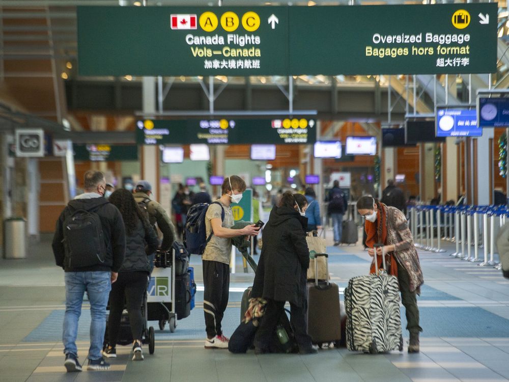 People move their luggage at Vancouver International Airport (YVR) on Dec. 16, 2021.