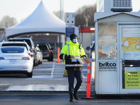 Motorists line up at the Sea Island COVID testing site in Richmond on Sunday as the Omicron variant continues to spread throughout B.C.
