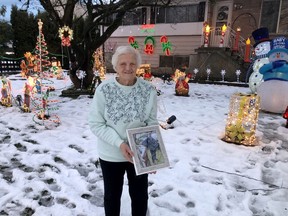 Wilma Louttit holds a photo of her late husband Roy in front of her Chilliwack home. With the help of friends and neighbours, the 81-year-old woman set up a Christmas light display to honour her husband. Experts say it's important to maintain our values as we head into what could be a challenging Christmas.