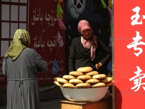 A Muslim ethnic Uighur woman sells bread on a street in Urumqi, capital of China's Xinjiang region, on July 3, 2010.