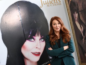 Actress Cassandra Peterson better know as Elvira, Mistress of the Dark, poses among memorabilia during the media preview of Julien's Auctions year end event "Icons and Idols: Hollywood" in Beverly Hills on Nov. 29, 2021.
