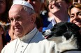 Pope Francis poses for a picture next to a dog after his general audience in St Peter's square at the Vatican on October 5, 2016.