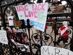 Protest signs are seen attached to the main gate to Parliament Hill, as demonstrations by truckers and their supporters against the coronavirus disease (COVID-19) vaccine mandates continue, in Ottawa, Ontario, Canada, January 31, 2022. REUTERS/Blair Gable