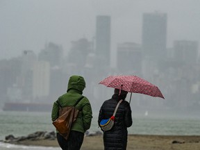 Peopl walk in the rain along Spanish Banks in Vancouver in a recent file photo.