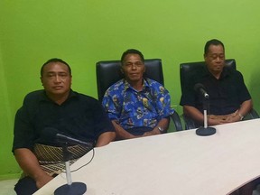 Lisala Folau (wearing blue printed shirt), a Tongan man who says he swam for around 27 hours after getting swept to sea by Saturday's tsunami, sits with other people of Atata island in Nuku'alofa, Tonga, January 19, 2022 in this picture obtained from social media.