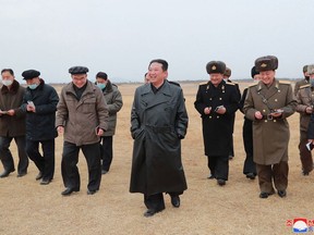 This undated picture released from North Korea's official Korean Central News Agency (KCNA) on January 28, 2022 shows North Korean leader Kim Jong Un (C) inspecting the planned construction site of a large-scale vegetable greenhouse farm in Ryonpho area of Hamju County, South Hamgyong Province, North Korea.