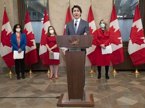 Defence Minister Anita Anand, Deputy Prime Minister and Finance Minister Chrystia Freeland and Foreign Affairs Minister Melanie Joly look on as Prime Minister Justin Trudeau speaks following a cabinet retreat earlier this week. Trudeau says Canada is extending its mission to train Ukrainian soldiers by three years.