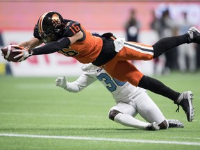 B.C. Lions' Bryan Burnham (16) dives across the goal line to score a touchdown in front of Toronto Argonauts' Trumaine Washington, back, after making a reception during first half CFL football action in Vancouver, Saturday, Oct. 5, 2019.