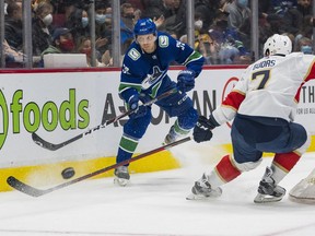 Vancouver Canucks forward Alex Chiasson passes the puck around Florida Panthers defenseman Radko Gudas in the first period at Rogers Arena. The Canucks lost 2-1 in a shootout.