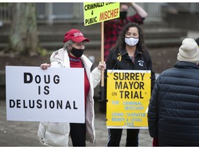 People outside the Surrey provincial court in Surrey, BC Tuesday, January 25, 2022 to protest mayor Doug McCallum during his first court appearance to answer charges of public mischief following his complaint he was hit by a car in a grocery store parking last year.