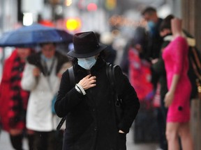 Pedestrians wrapped up as a rainfall warning has been issued for the Lower Mainland, with heavy rain set to begin Tuesday afternoon through Wednesday afternoon in Metro Vancouver, the Fraser Valley, Howe Sound and the Sunshine Coast with about 75 to 100 mm expected to fall and more precipitation over the Coast Mountains.