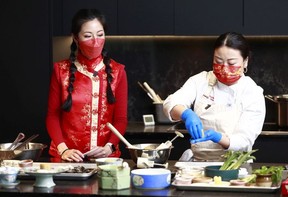 MC Manica Ng, left, looks on as chef Yuyina Zhang prepares a dish from her hometown in Yunnan province, China, during a Zoom cooking class.