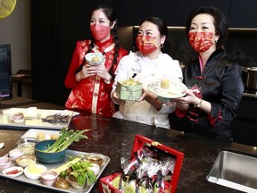 Manica Ng, Yuyina Zhang and Helen Yu hold up dishes Zhang prepared during a Zoom cooking class in Richmond. Zhang made Yunnan Ghost Chicken Salad and Golden Chestnut Pastry for her Zoom audience.