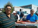 Kelly en Johnny Louis zijn kanobouwers van Musqueam Nation, hier te zien met de Savage Warrior-kano die ze hebben gerestaureerd en die werd gebouwd door Dominic Point en die te zien is in het Musqueam Community-gebouw.