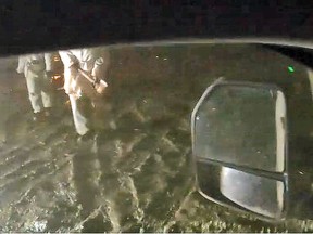 An attacker wielding an axe approaches workers fleeing in a vehicle during the attack at the Coastal GasLink camp near Houstion early on Feb. 17, 2022. This image, taken as the attack started, was provided by the company. A short time later, attackers disabled the surveillance equipment.