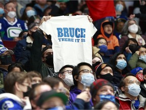 A Vancouver Canucks fan holds up a t-shirt during the NHL game between the Vancouver Canucks and the Columbus Blue Jackets at Rogers Arena December 12, 2021 in Vancouver.