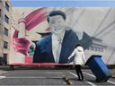 China könnte das patriotischste Land der Welt sein, sagt Prof. Bruce Dickson, Autor von The Party and the People.  (Foto: Eine Frau schleppt eine Mülltonne auf Rädern an einer verblichenen Propagandaplakatwand vorbei, auf der Chinas Präsident Xi Jinping abgebildet ist.)
