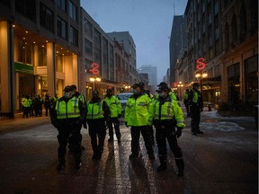 Police officers gather on a street during a protest by truck drivers over pandemic health rules and the Trudeau government, outside the parliament buildings in Ottawa.