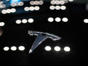 In this file photo taken on May 26, 2021 a Tesla logo is seen on a Tesla car Model 3, inside of a Tesla shop inside of a shopping Mall in Beijing.