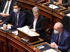 Attorney-General David Eby, left, and Premier John Horgan flank Finance Minister Selina Robinson as she delivers the budget speech in the legislative assembly on Tuesday.
