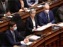 Attorney General David Eby (left) and Premier John Horgan watch Finance Minister Selina Robinson deliver the budget speech at the Legislative Assembly in Victoria, British Columbia, Tuesday, February 22, 2022.