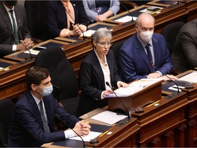 Attorney General David Eby (left) and Premier John Horgan look on as Finance Minister Selina Robinson delivers the budget speech in the legislative assembly at legislature in Victoria, B.C., on Tuesday, Feb. 22, 2022.