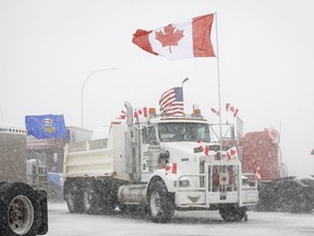 Anti-mandate demonstrators gather as a truck convoy blocks the highway the busy U.S. border crossing in Coutts, Alta., Monday, Jan. 31, 2022.