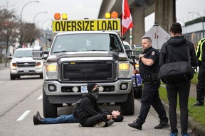 Gegendemonstranten blockieren einen Konvoi, während Trucker und Unterstützer am 5. Februar 2022 in Vancouver weiterhin gegen die Impfmandate gegen die Coronavirus-Krankheit (COVID-19) protestieren.