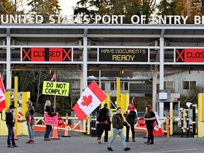 A convoy of truckers and supporters protest COVID-19 vaccine mandates at a closed border on Pacific Highway near the border in Surrey Saturday.