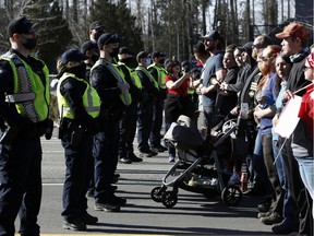 Polizeibeamte halten eine Reihe von Demonstranten zurück, während Trucker und Unterstützer weiterhin gegen die Impfmandate für die Coronavirus-Krankheit (COVID-19) in der Nähe des Grenzübergangs zwischen Kanada und den USA in Surrey, British Columbia, Kanada, am 13. Februar 2022 protestieren. FOTO VON JESSE WINTER /REUTERS