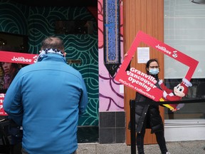 Woman poses in front of Jollibee restaurant in Vancouver on Feb. 26, 2022.