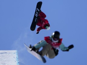 Canadian snowboarder Liam Gill, top, joins fellow athletes as they train in the halfpipe at the Beijing Winter Olympic Games, in Zhangjiakou, China, Sunday, Feb. 6, 2022.