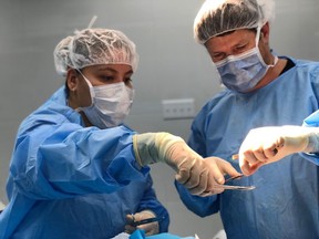 Physician assistant Joanna Chan (left) assists plastic surgeon Dr. Michel Gallant with the placement of a skin graft to a child's head during an operation in Port-au-Prince, Haiti, in a 2018 handout photo. Chan was part of a medical team with the organization Team Broken Earth.