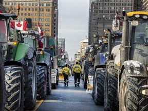 Toronto Police officers walk through farm tractors just north of Queens Park as farmers and truckers have started to enter downtown Toronto.