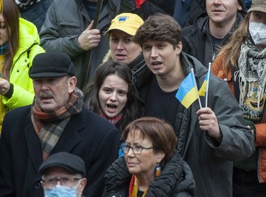 People hold signs and flags as thousands gather for a rally in support of the people of Ukraine, in Vancouver, on Saturday, February 26, 2022.