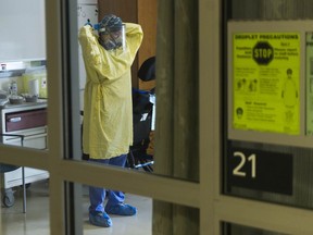 A nurse prepares to treat a patient in the ICU at Surrey Memorial Hospital.